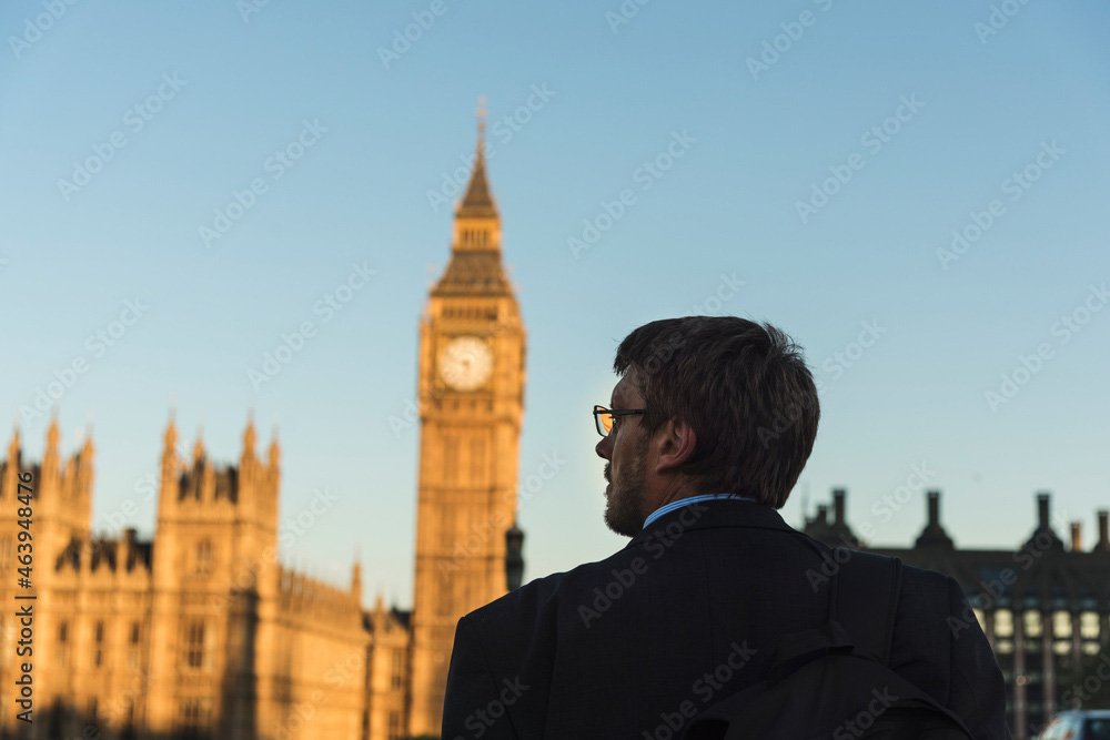 Man in suit with glasses overlooking London with Big Ben in forefront.