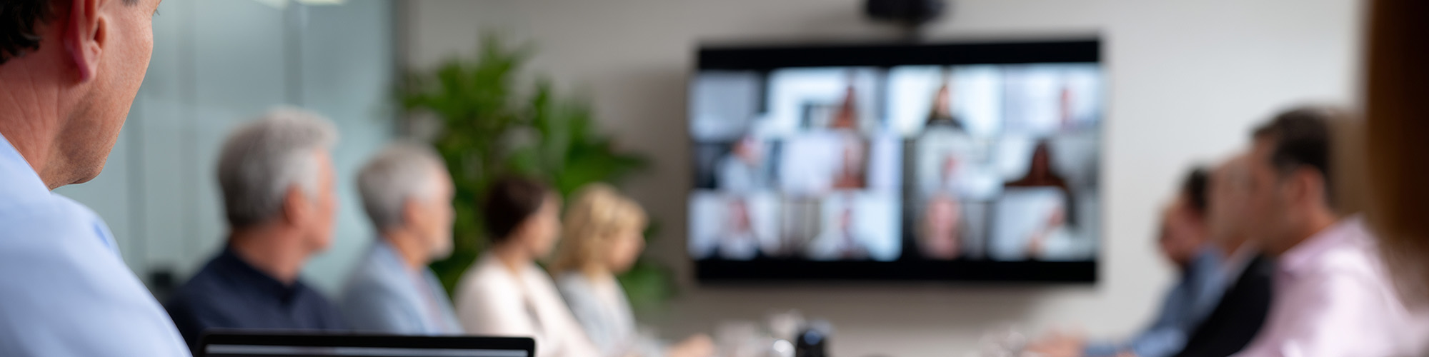 Blurry photo of people in office with video call on screen
