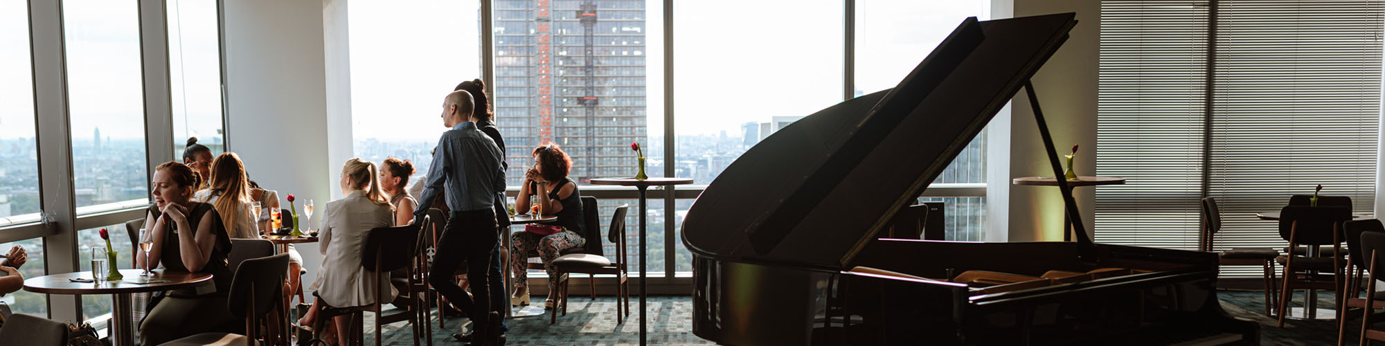People in high building on tables with piano